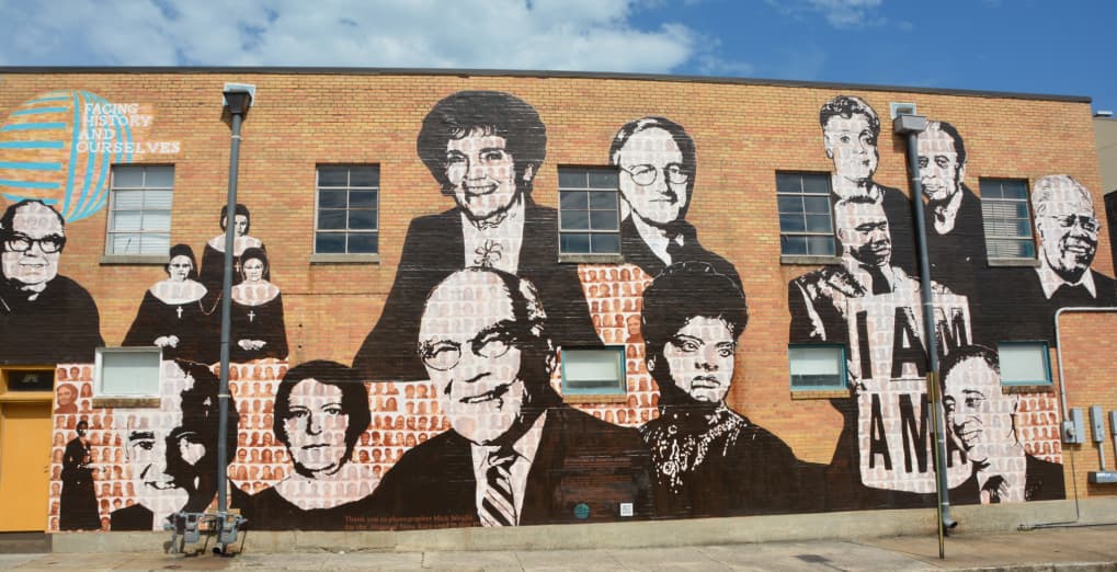 Outside of a building on the Civil Rights Tour with historical images of Civil Rights leaders painted on it