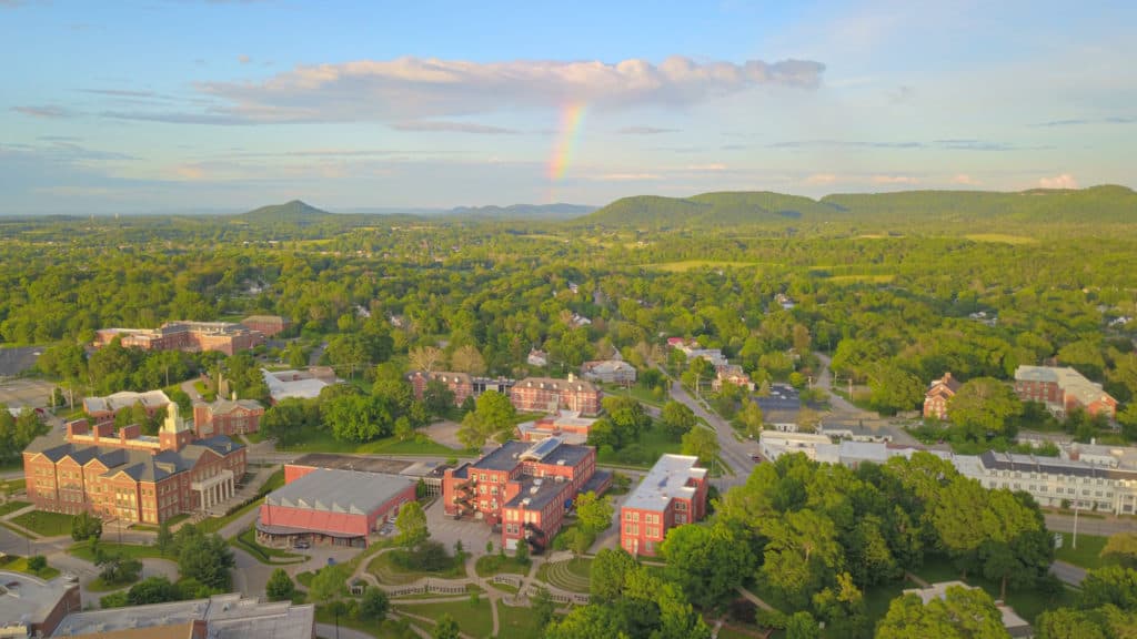 Drone photo over campus with a rainbow in the background