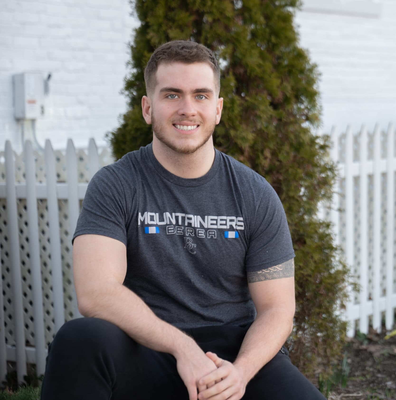 Aidan sitting down smiling at camera